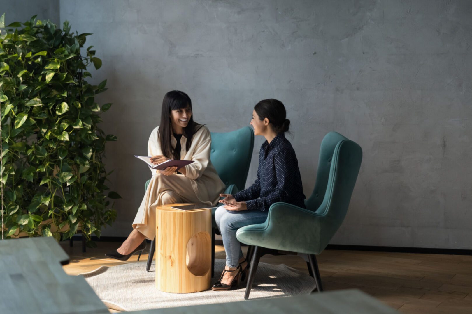 Two women having a conversation in chairs.